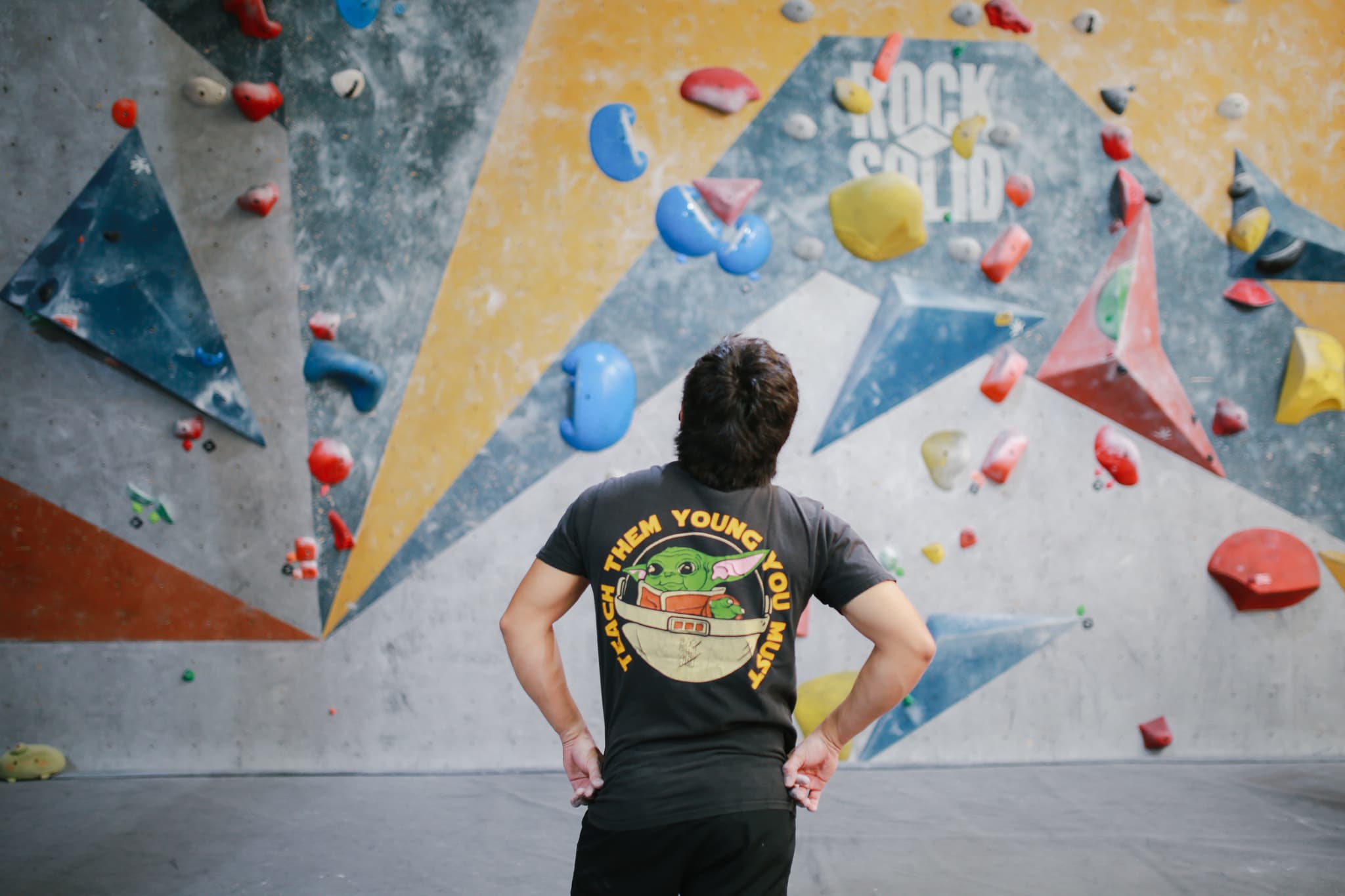 Escalador en movimiento dinámico sobre la pared de boulder